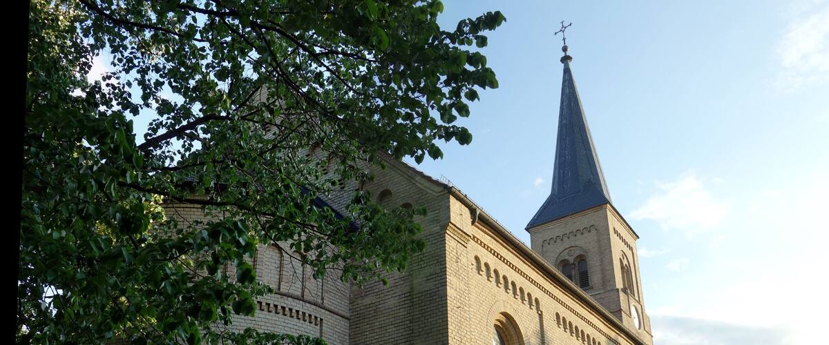 A church with a tall steeple and arched windows.