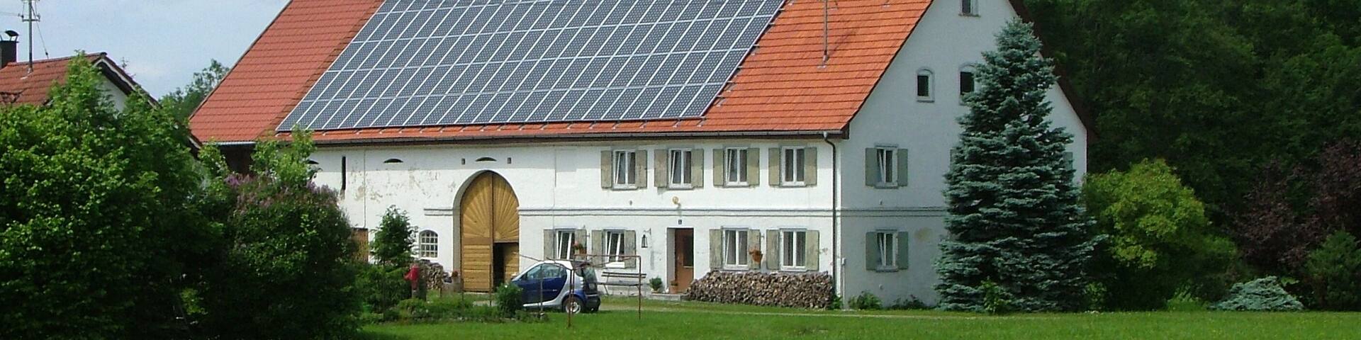 A house with a red roof and solar panels.