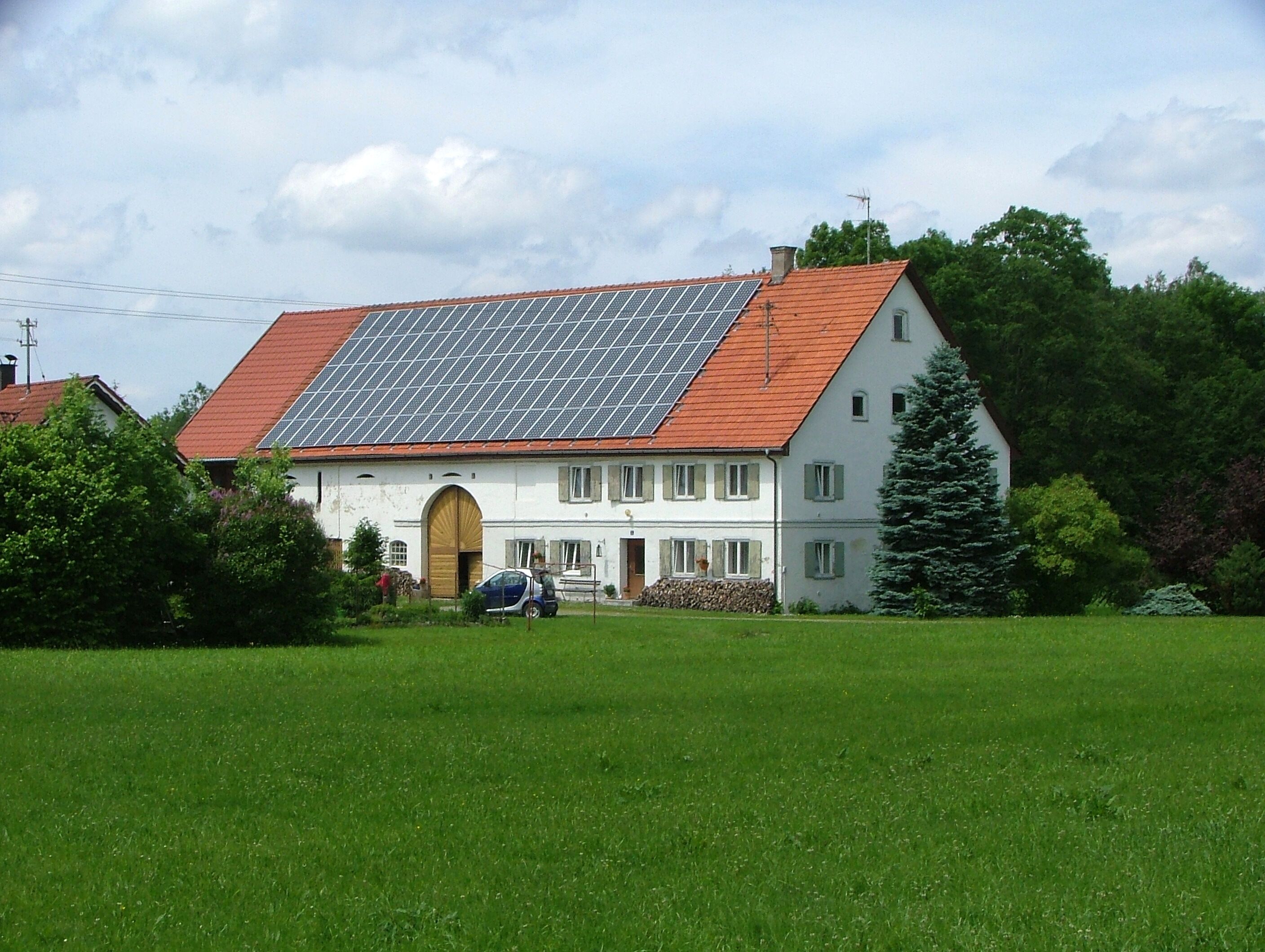 A house with a red roof and solar panels.