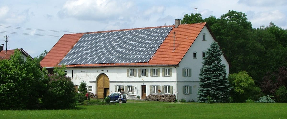 A house with a red roof and solar panels.