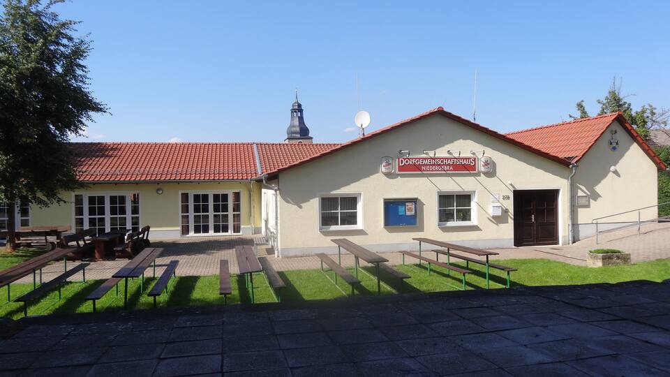 A building with a red-tiled roof and a sign reading "Dorfgemeinschaftshaus Niedergreben".