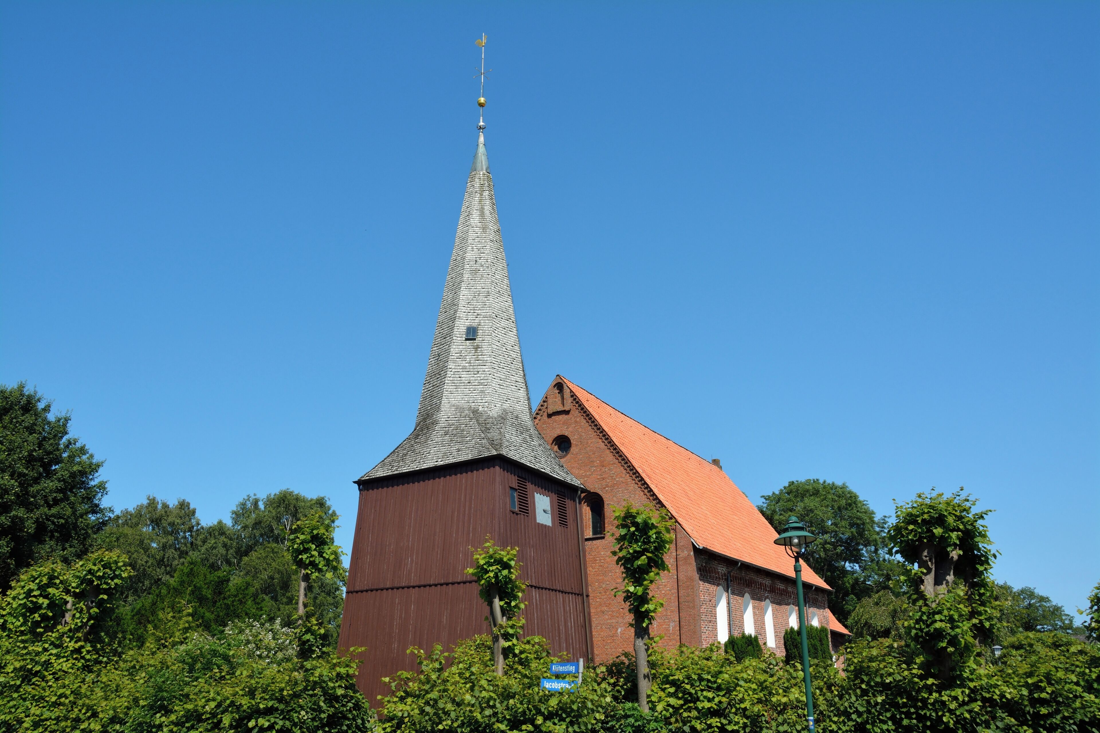 A church with a tall steeple and a red roof.