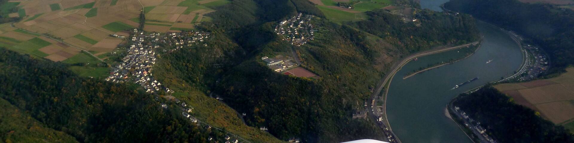 A river winding through a valley with fields and small settlements.