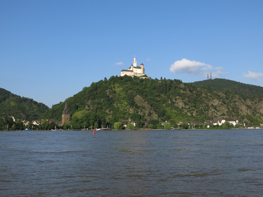 A castle on a hill with a river in the foreground.