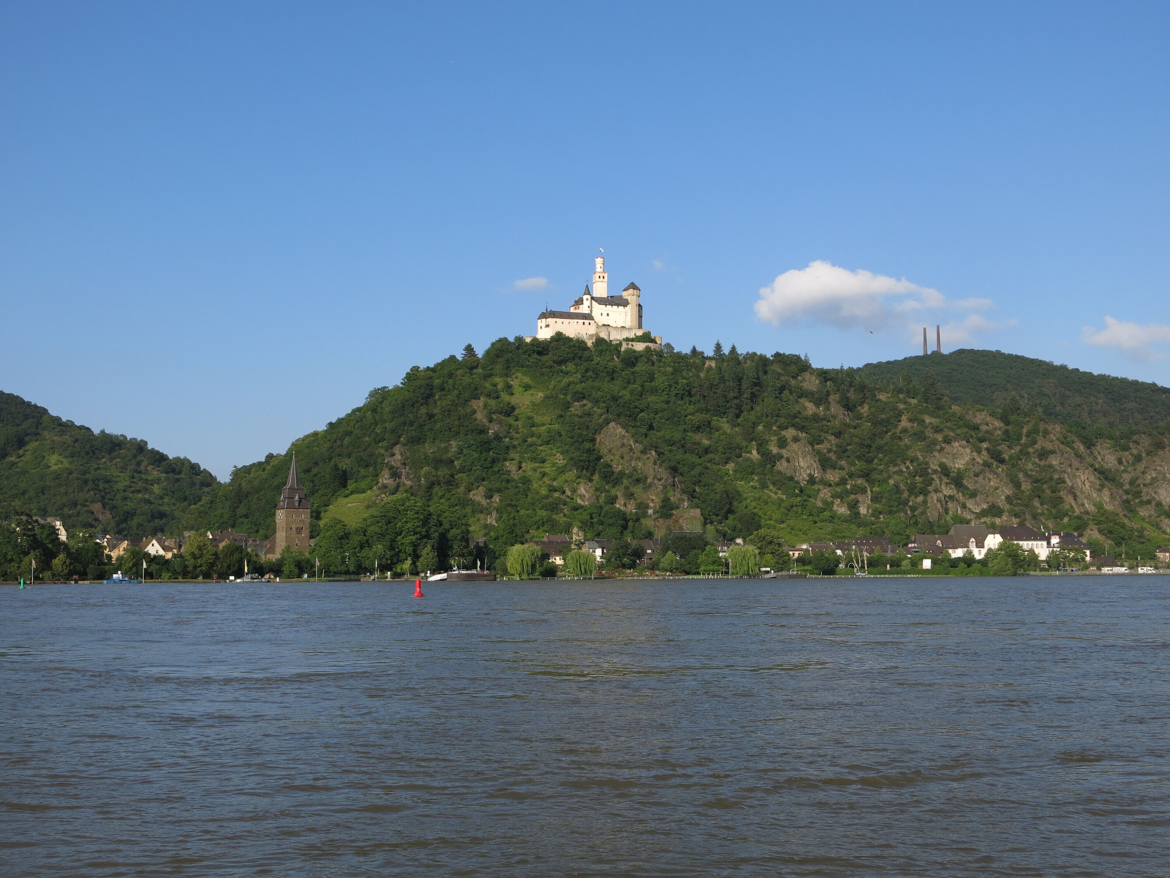 A castle on a hill with a river in the foreground.