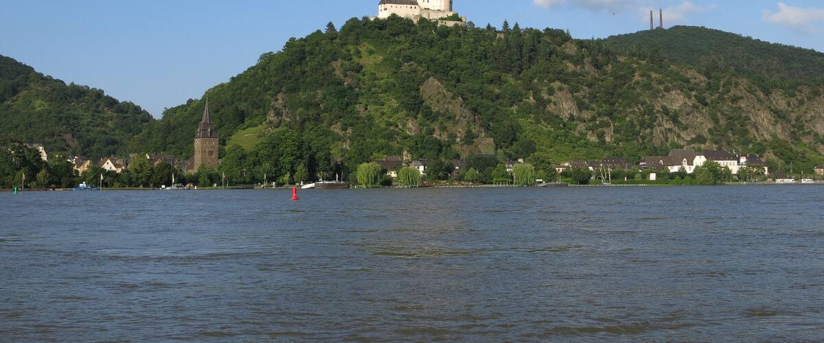 A castle on a hill with a river in the foreground.