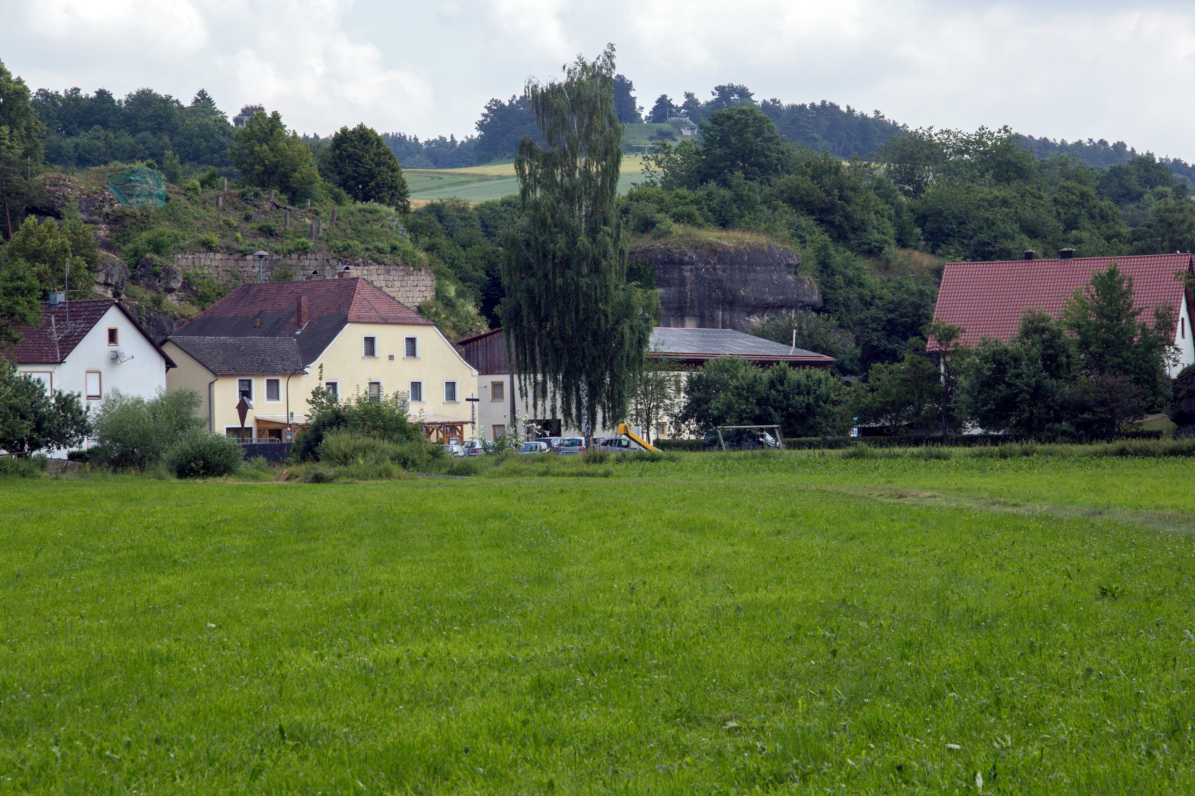A rural landscape with houses, a playground, and a green field.
