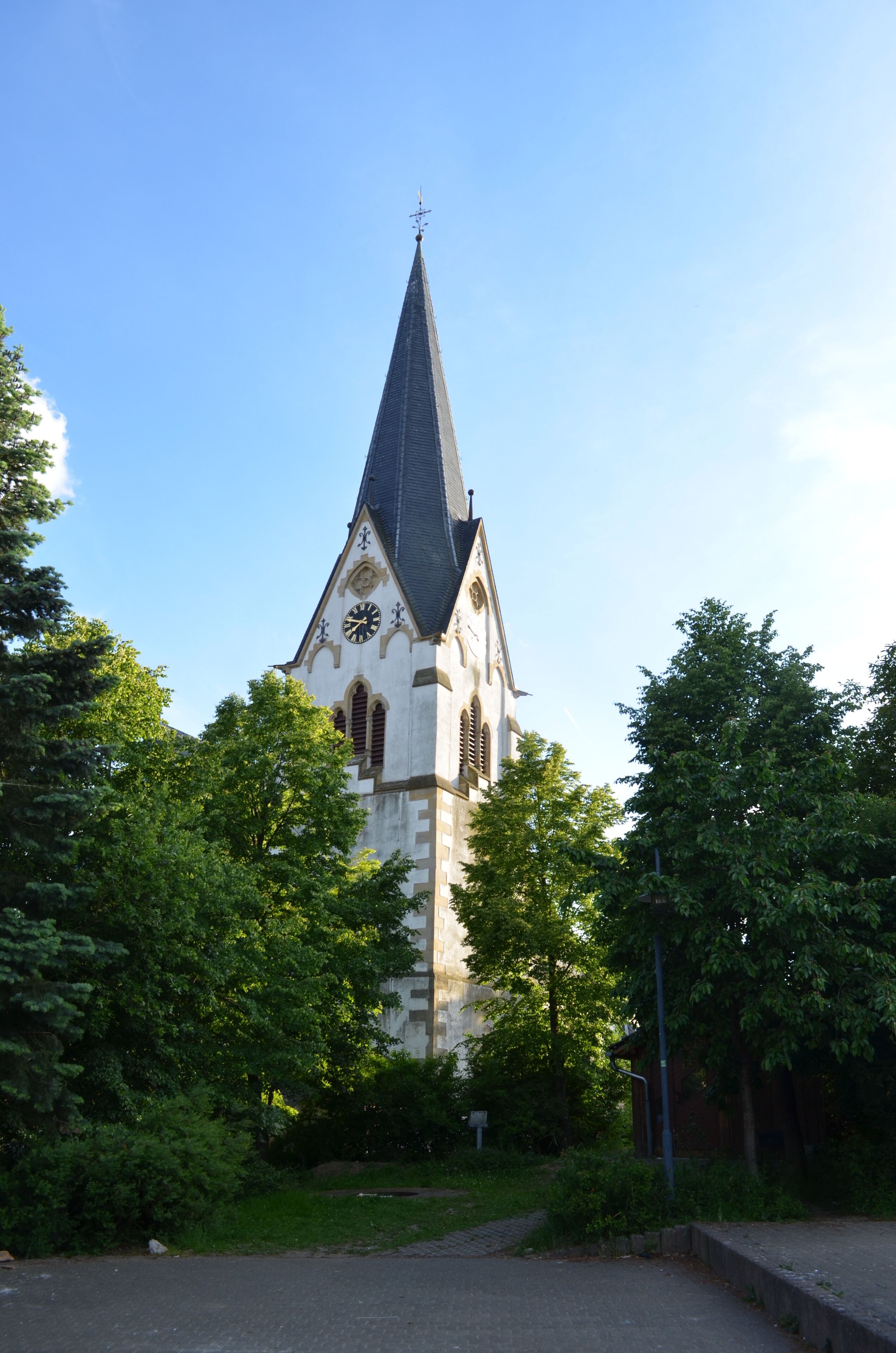A church with a tall spire and a clock.
