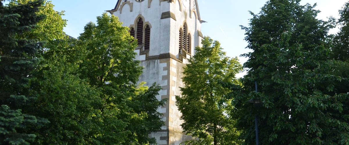 A church with a tall spire and a clock.