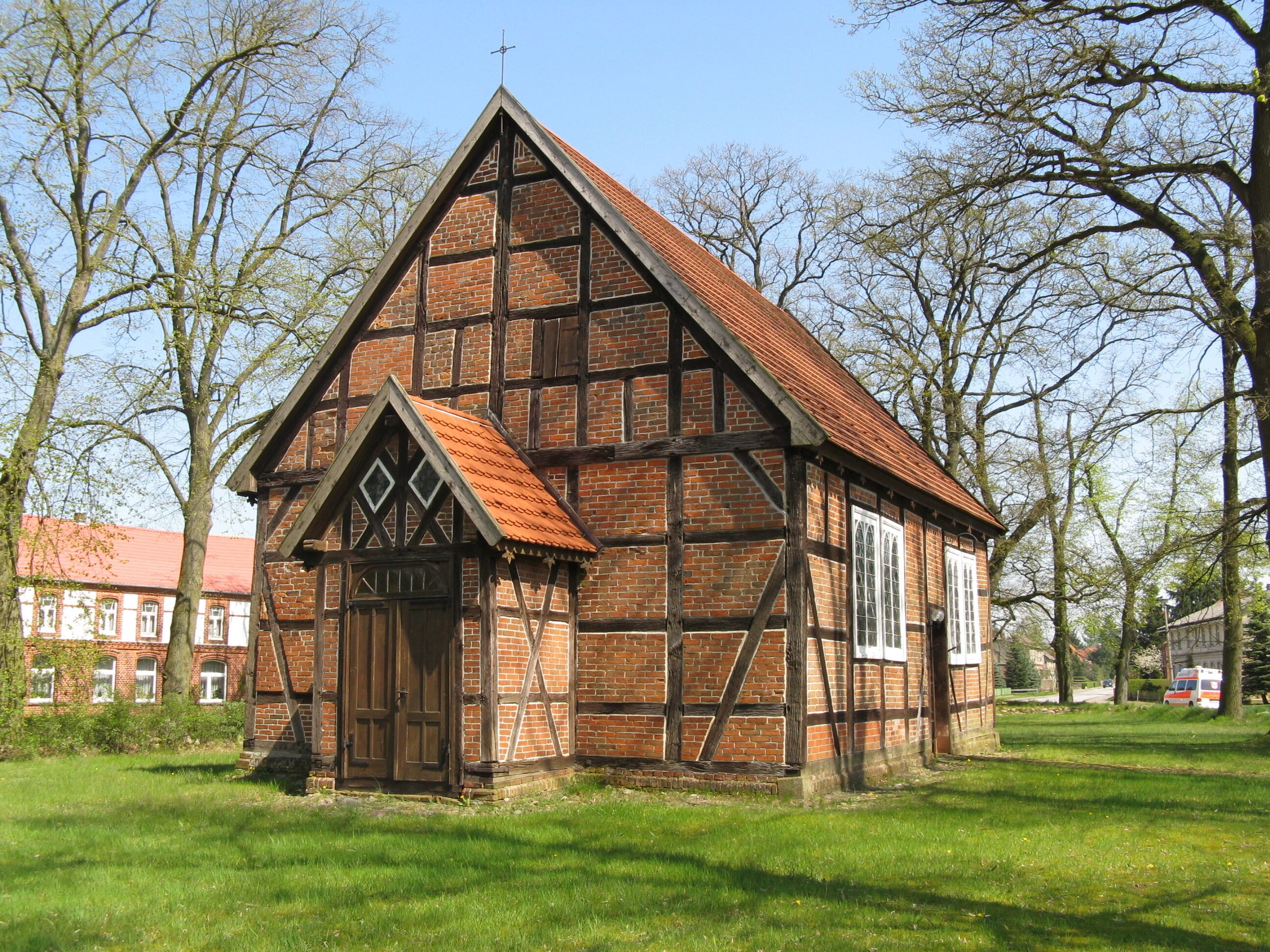 A traditional half-timbered church with a steep gable roof and a wooden door.