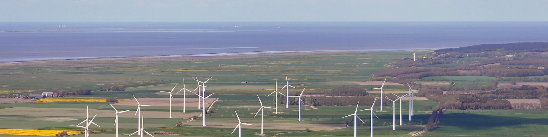 Luftbilder von der Nordseeküste 2012-05; die Straße im rechten unteren Drittel ist der Neuer Weg in Nordholz, im Hintergrund das Wurster Watt, in der Bildmitte ein Windpark