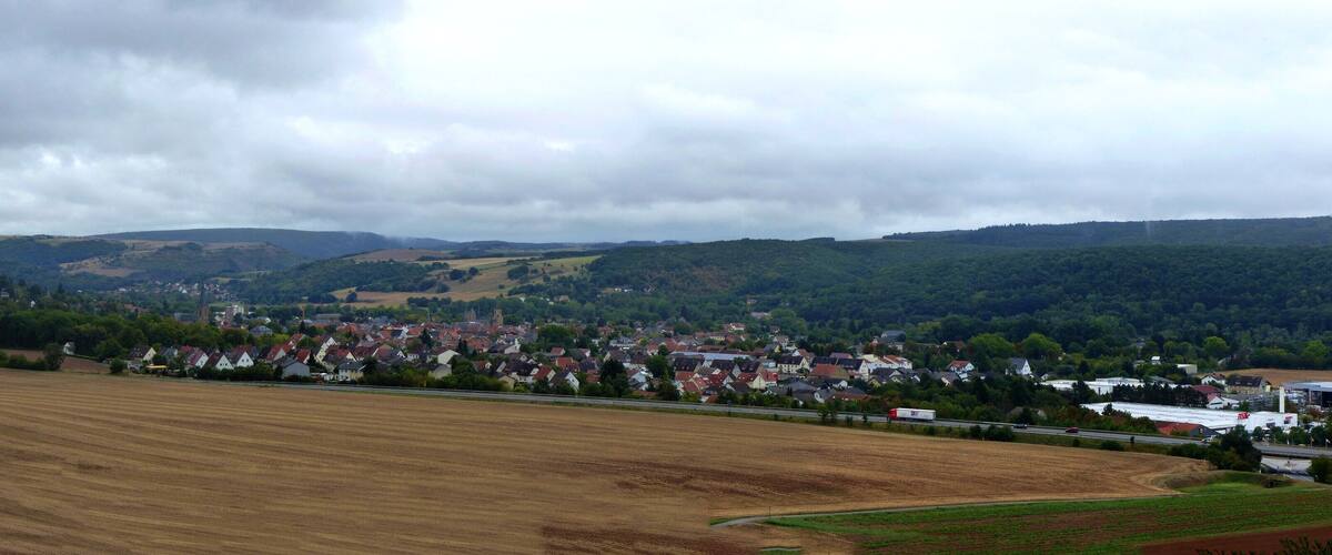 A rural landscape with fields, a small town, and rolling hills.