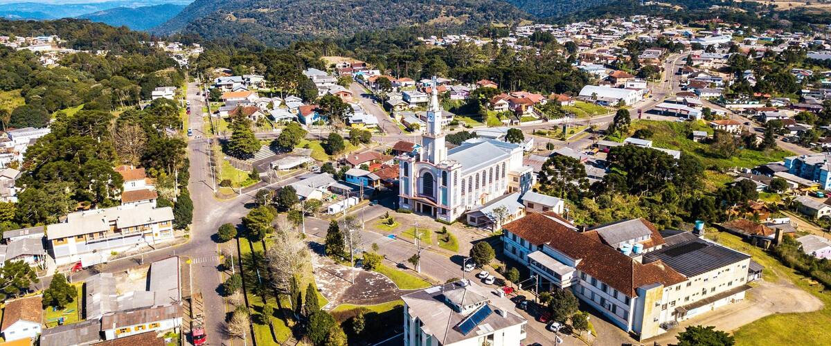 A town with a prominent church, residential areas, and rolling hills in the background.