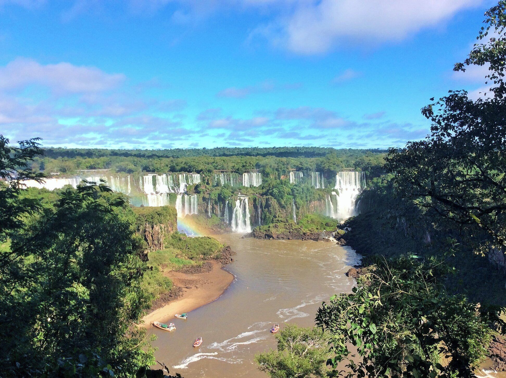 A river with multiple waterfalls surrounded by dense greenery.