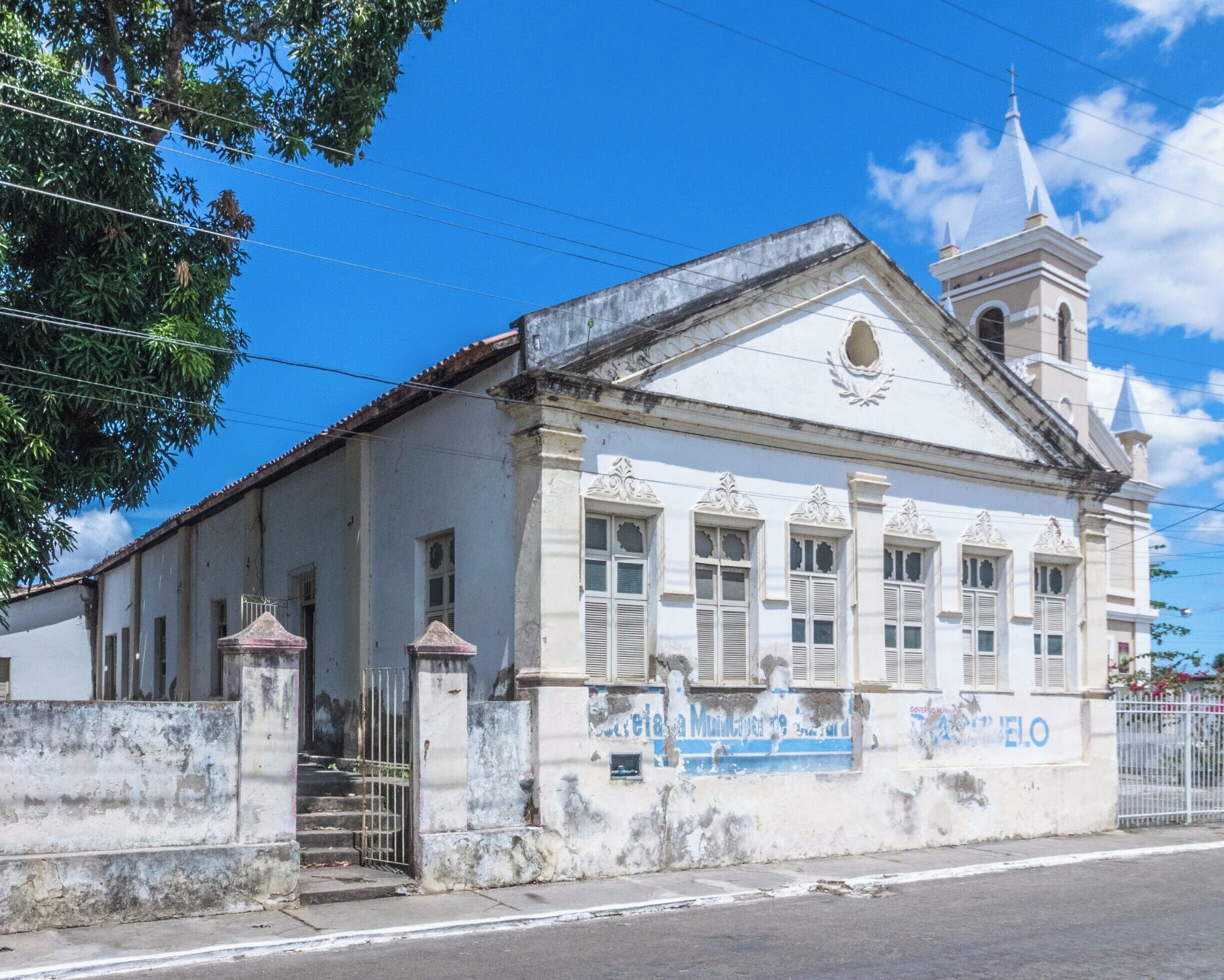 A historic building with a white facade, a bell tower, and a sign reading "Municipio de Cienfuegos".