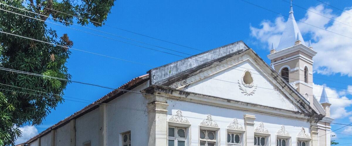 A historic building with a white facade, a bell tower, and a sign reading "Municipio de Cienfuegos".