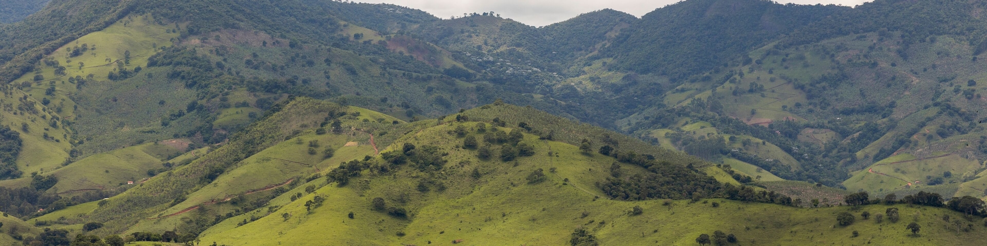 Uma cidade aninhada num vale, com colinas verdes ondulantes e uma igreja imponente.