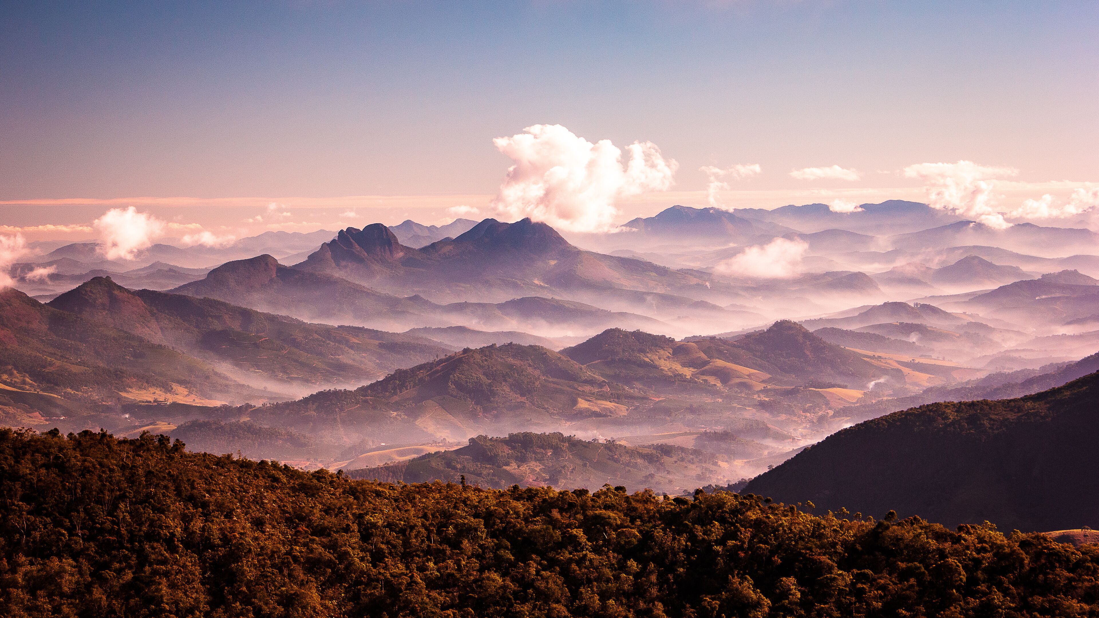 A mountainous landscape with rolling hills and dense forests.