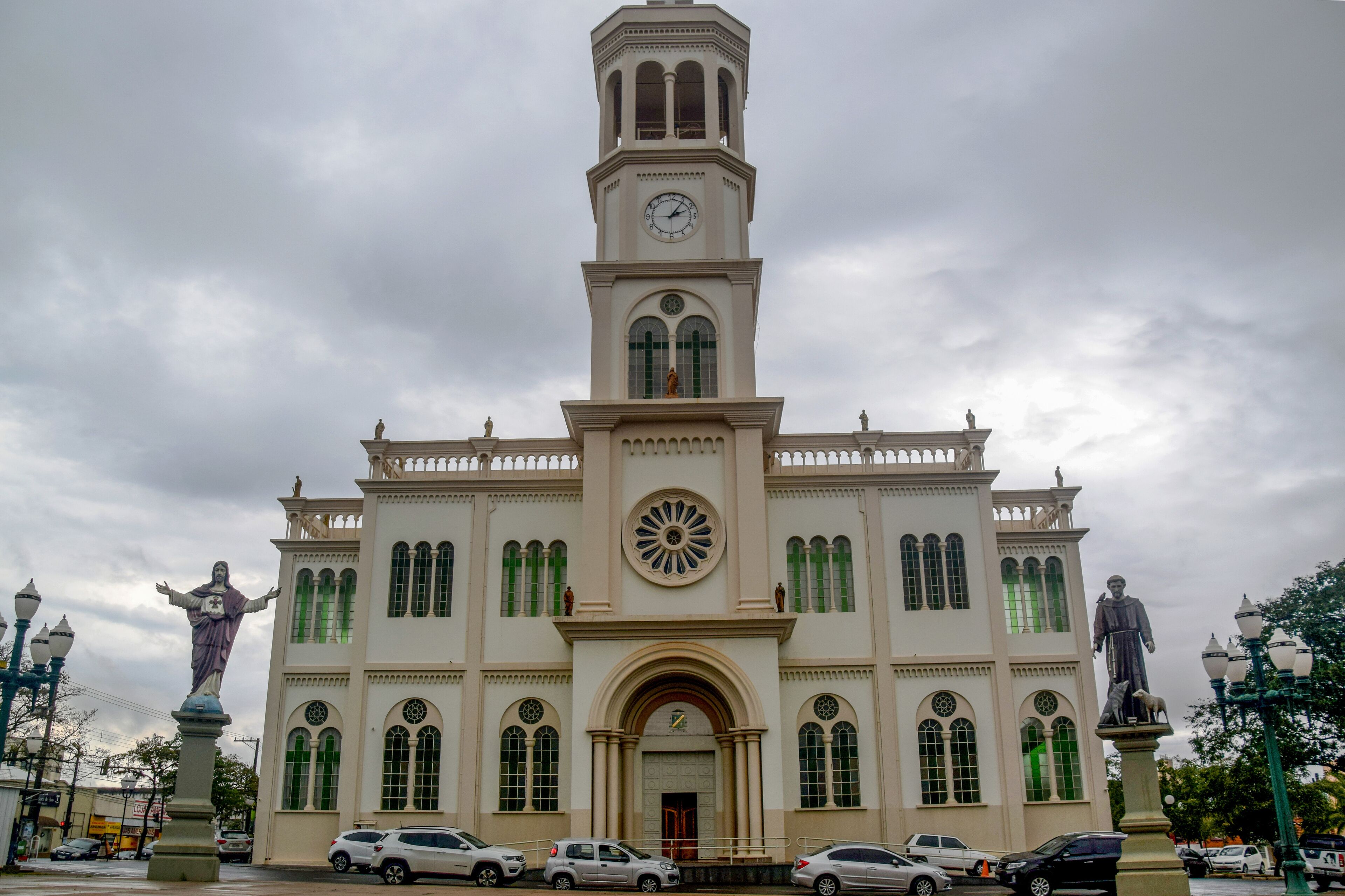 A historic building with a clock tower, statues, and arched windows.