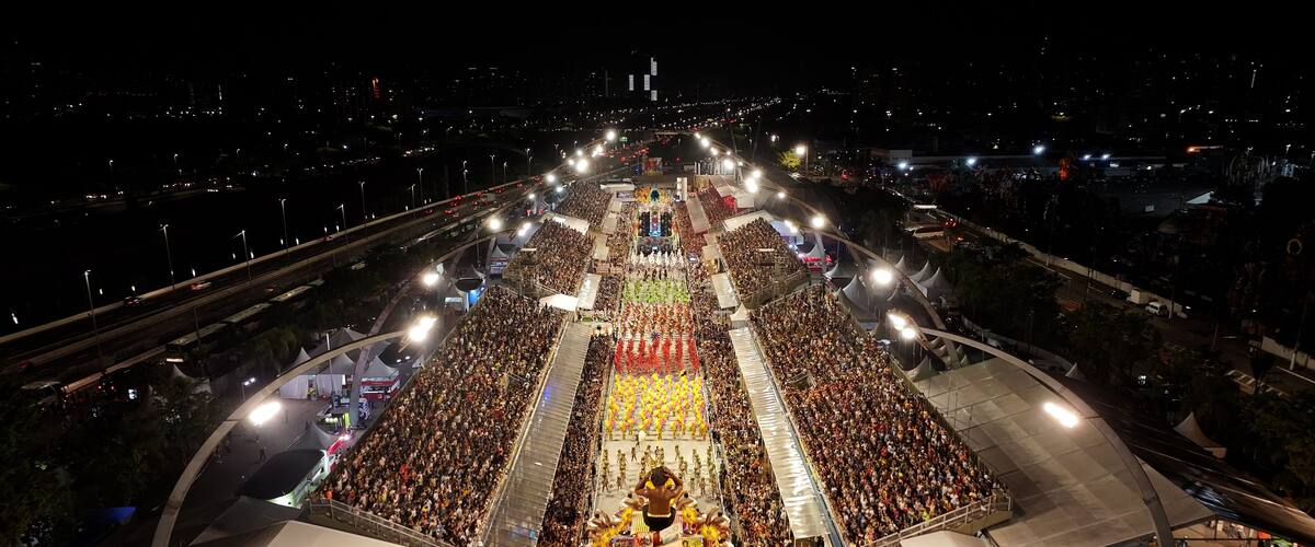 A large outdoor event with a central stage and a crowd.