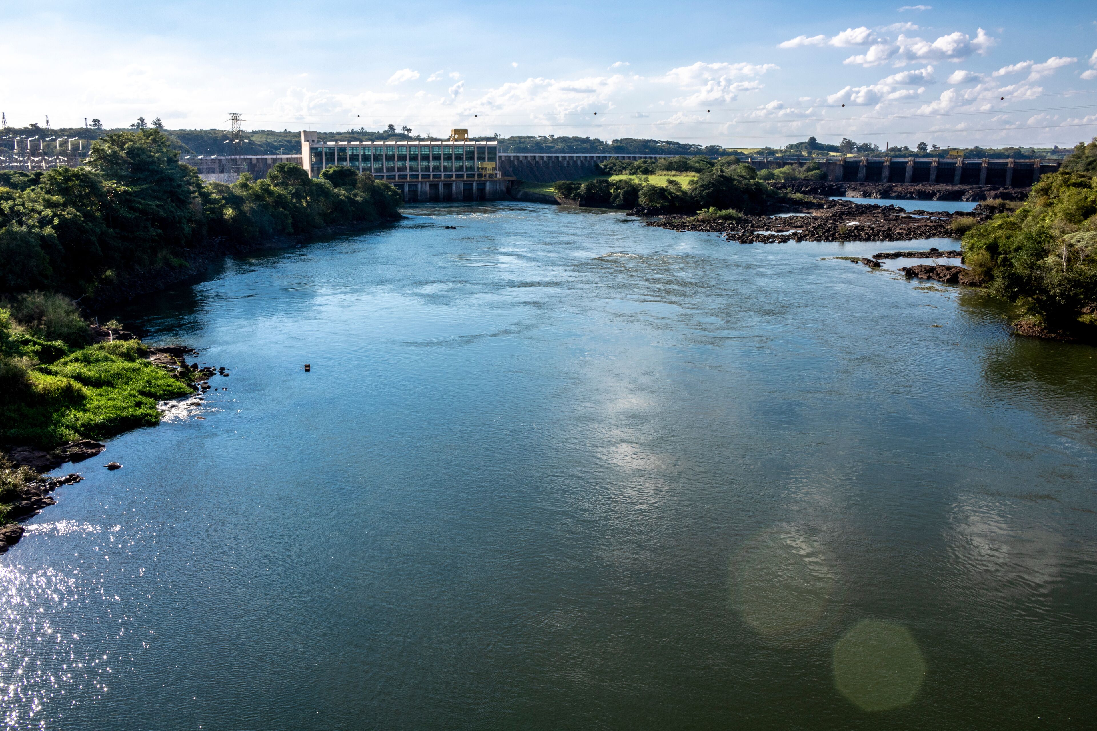 A river with a dam and surrounding greenery.