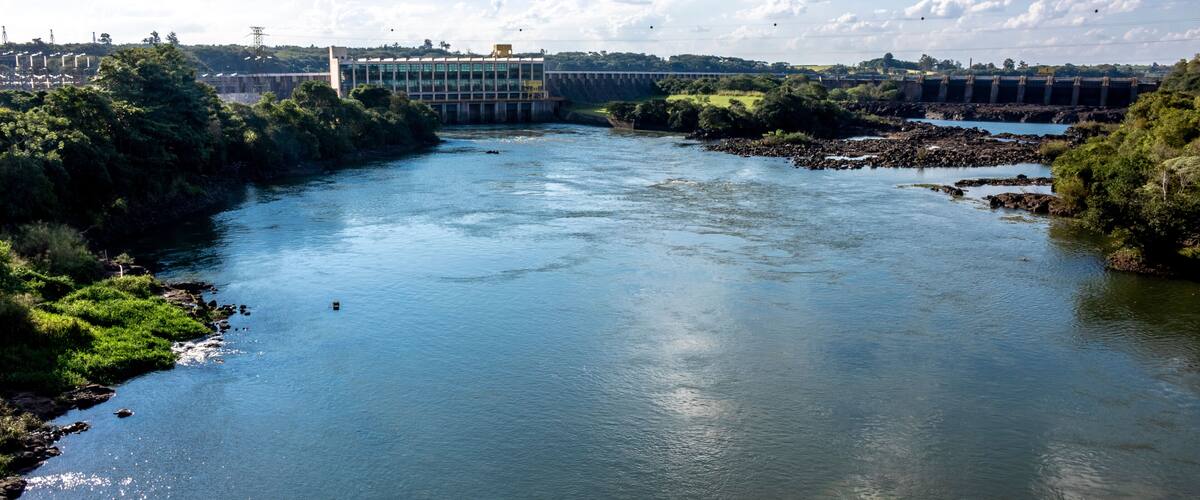 A river with a dam and surrounding greenery.