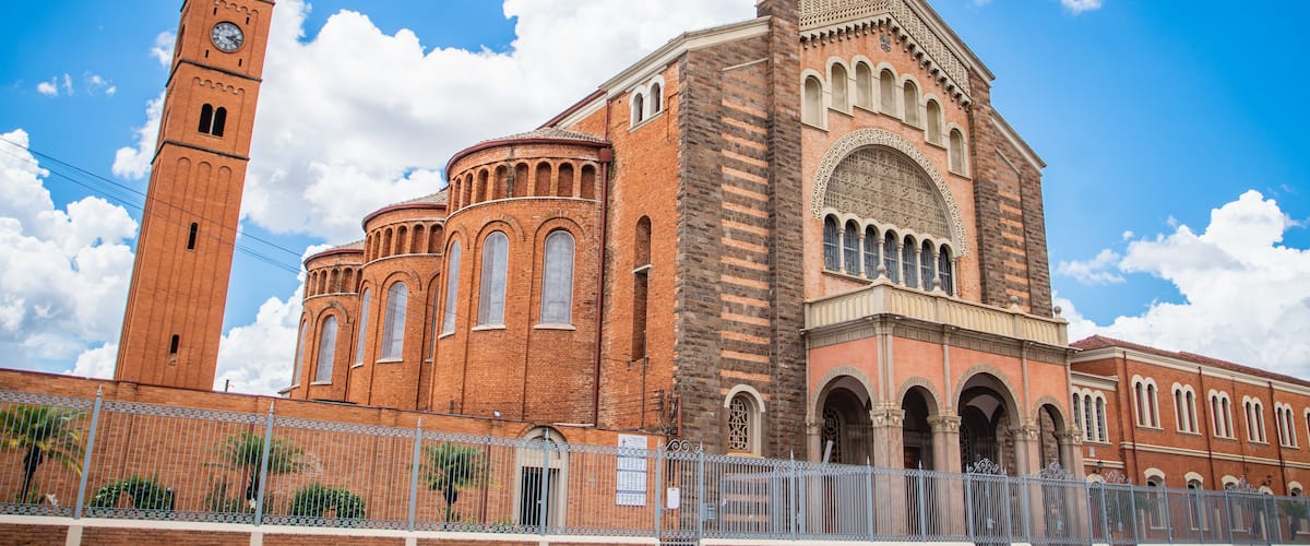 A large brick church with a clock tower and arched windows.