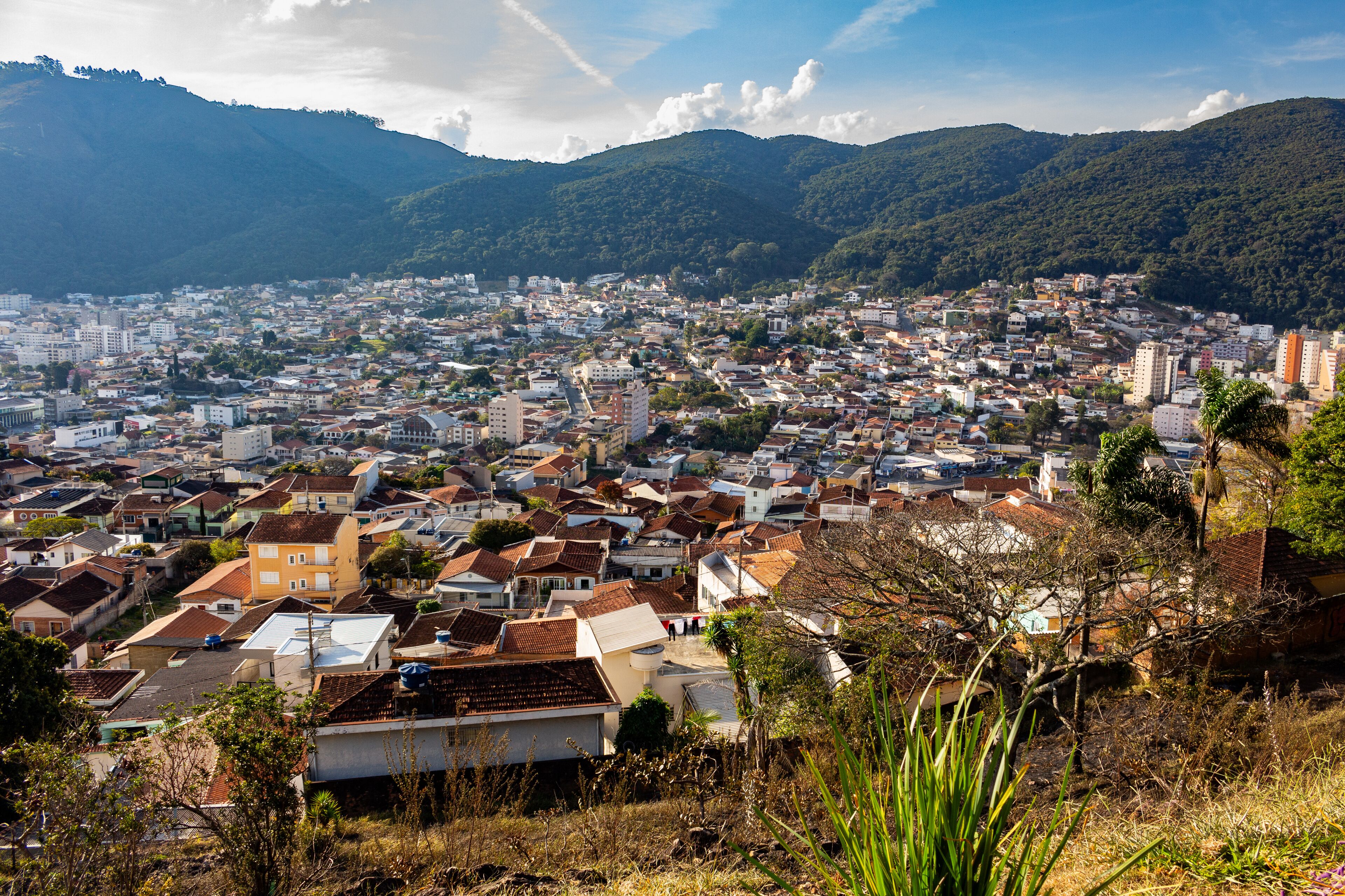 A city nestled in a valley with mountains in the background.