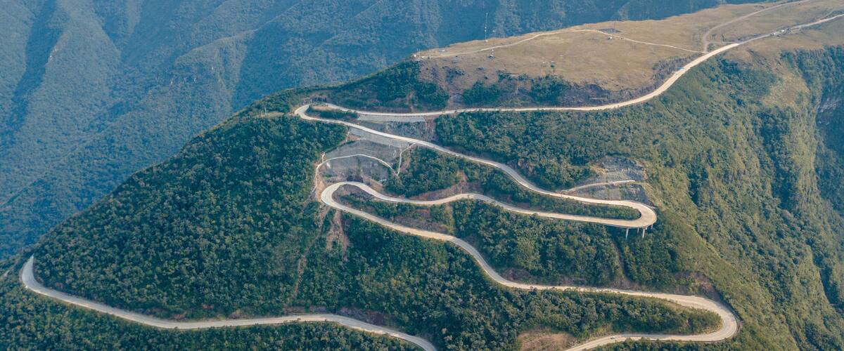 A winding mountain road through a forested valley.