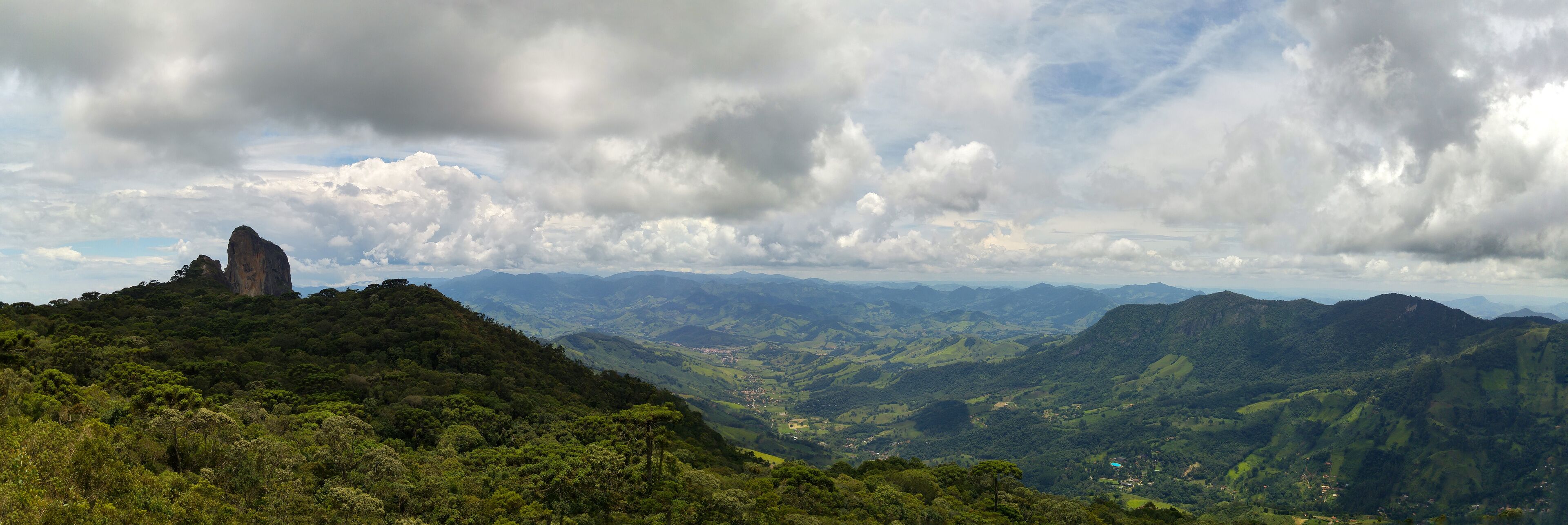 A mountainous landscape with a prominent rock formation and lush green valleys.