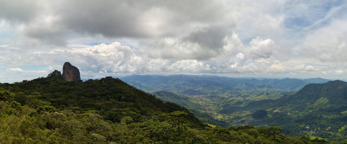 A mountainous landscape with a prominent rock formation and lush green valleys.