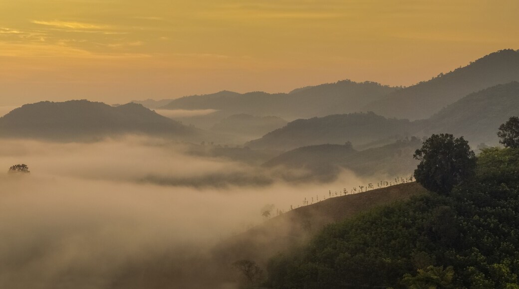 sunrise at Phu Huay E San View Point, view of the hill around with sea of mist above Mekong river with yellow sun light in the sky background, Ban Muang, Sang Khom District, Nong Khai, Thailand.