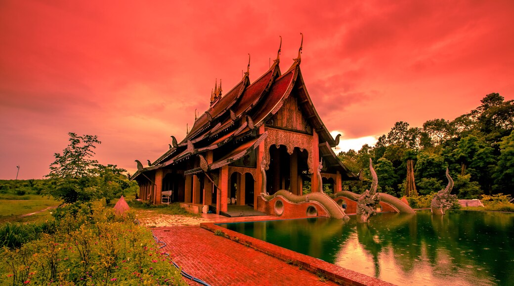 The background of the Wat Pa Kham Charoen is a beautiful old church with a Buddhist statue and a tree-lined temple, with tourists and travelers always making merit in Udon Thani, Thailand.