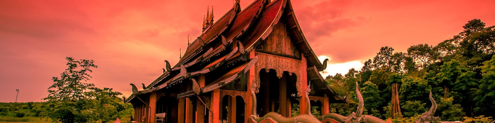 The background of the Wat Pa Kham Charoen is a beautiful old church with a Buddhist statue and a tree-lined temple, with tourists and travelers always making merit in Udon Thani, Thailand.