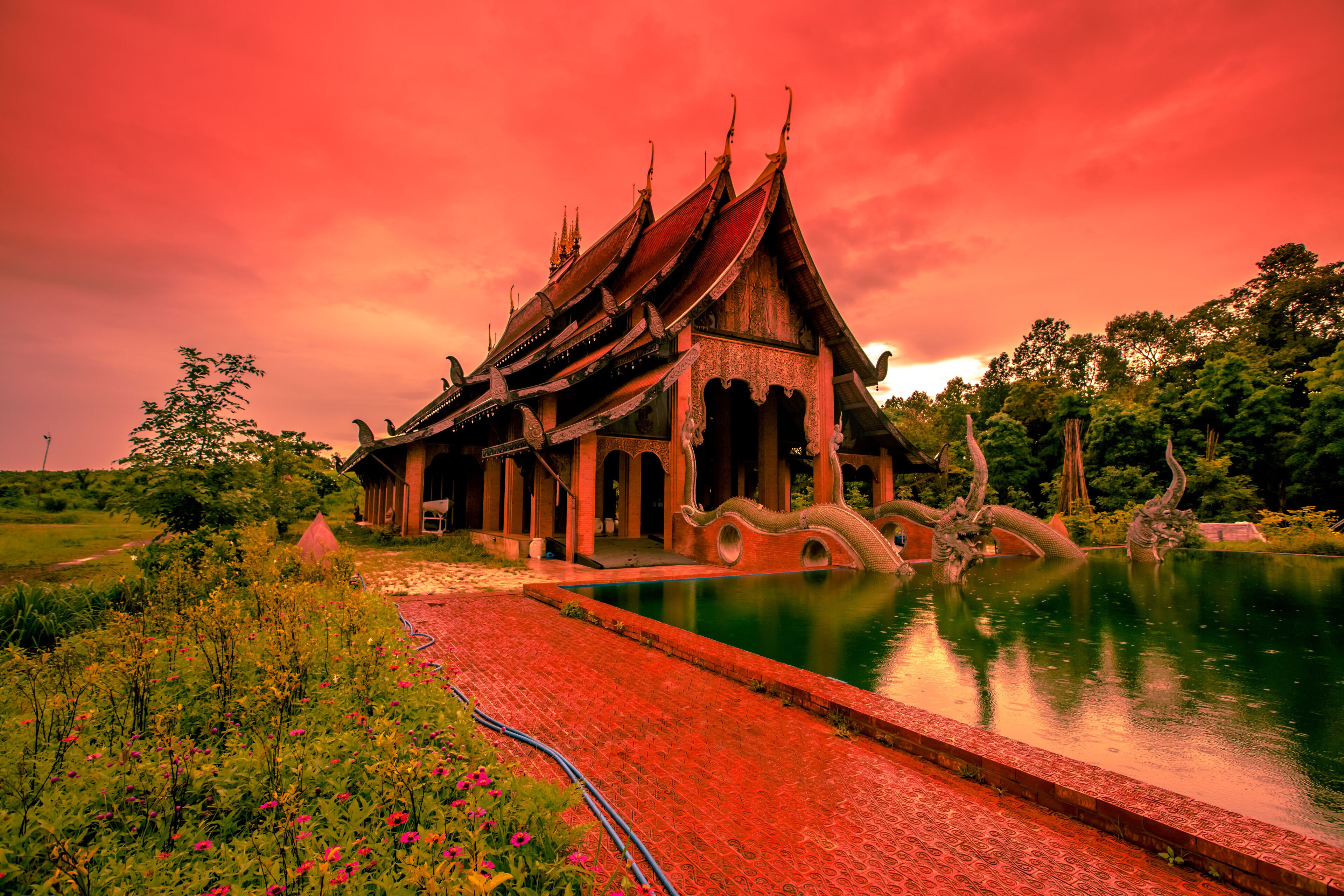 A traditional temple with ornate architecture, a lotus pond, and a vibrant garden.