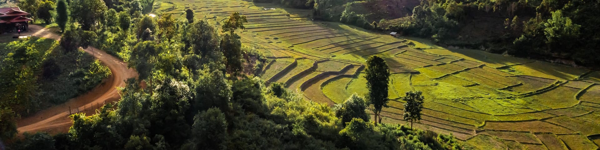 Aerial view of terraced agriculture field among greenery mountains with the blue cloudy and sunlight in the northern of Thailand, Omkoi district, Chiang Mai.