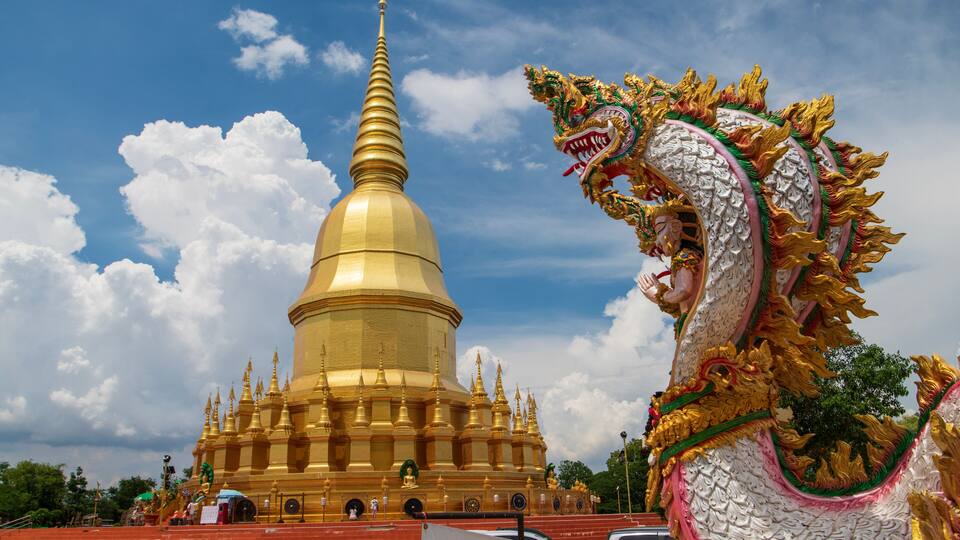 A golden stupa with a dragon statue in front.