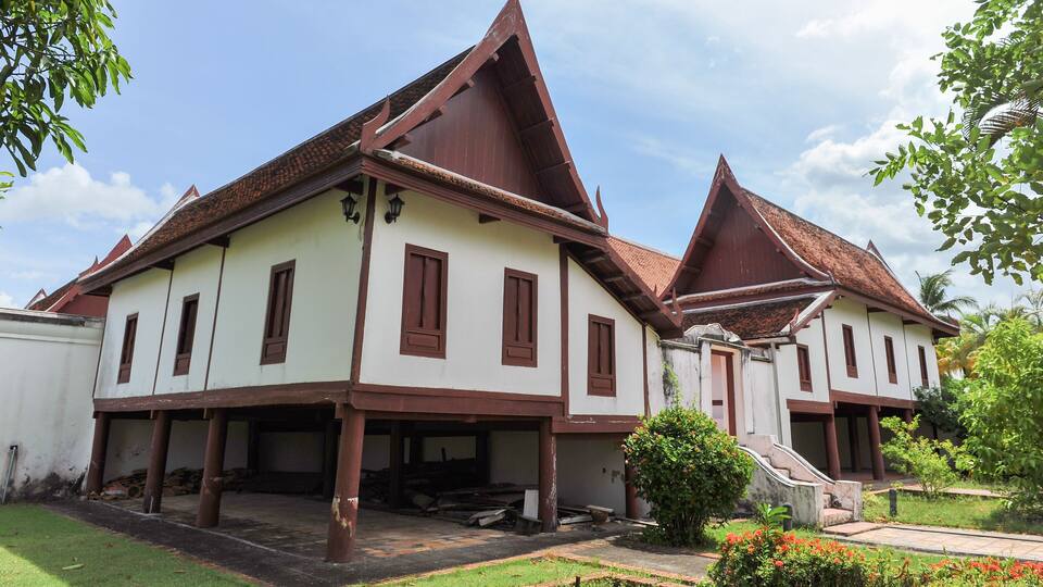 A traditional building with a steeply pitched roof and a small staircase leading to the entrance.