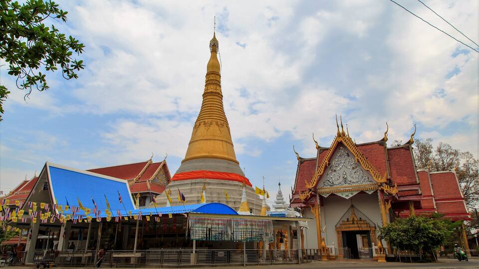 A large stupa with a golden spire, surrounded by traditional Thai architecture.
