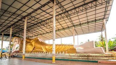 Big reclining Buddha in Wat Thai Wattanaram which is a Thai temple that is built in the style of Myanmar There is a beautiful golden color in Mae Sot District, Tak Province, Thailand.