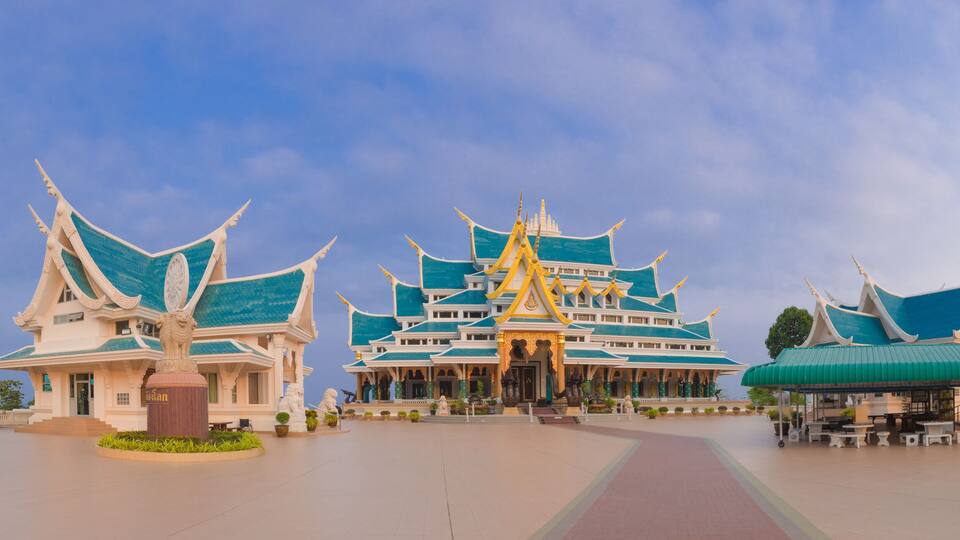 A traditional Thai temple complex with ornate architecture and statues.