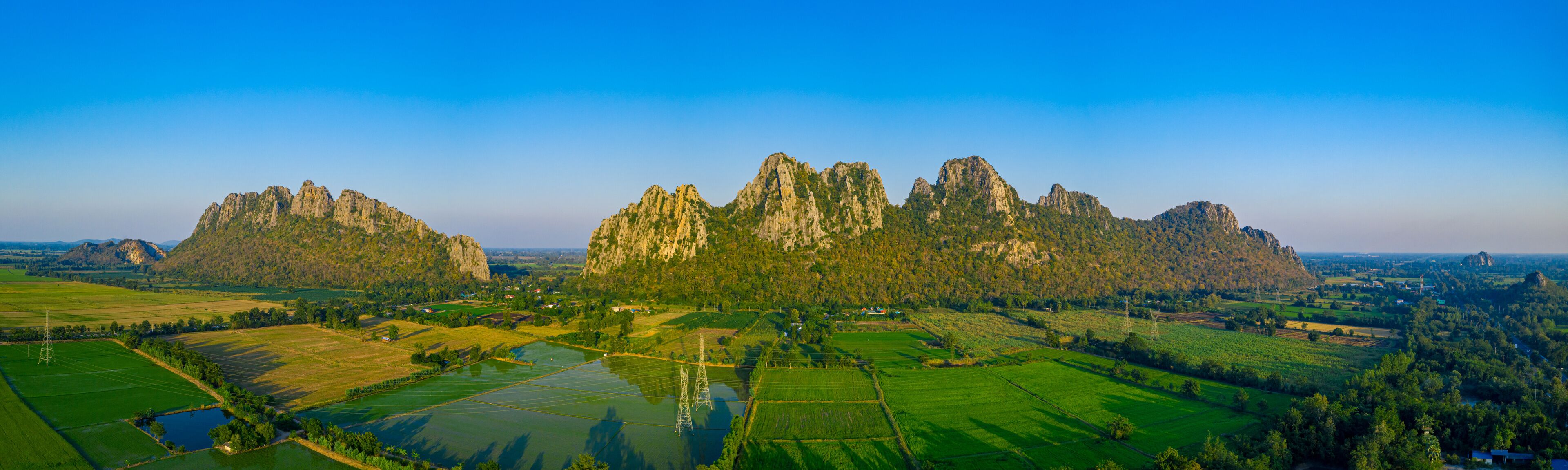 A mountainous landscape with green fields and a river.