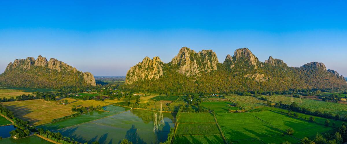 A mountainous landscape with green fields and a river.