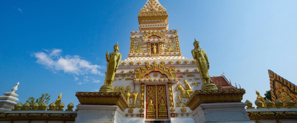 A multi-tiered temple with golden statues and intricate designs.