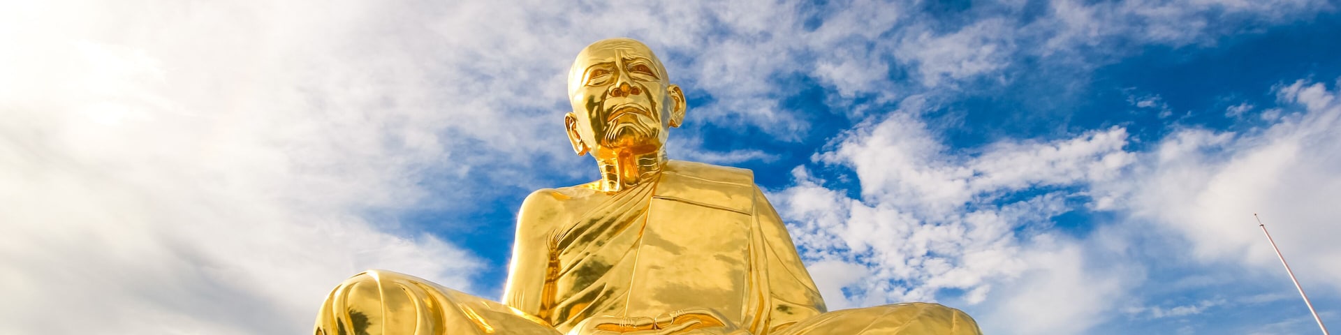 A large golden Buddha statue with a plaque in front.