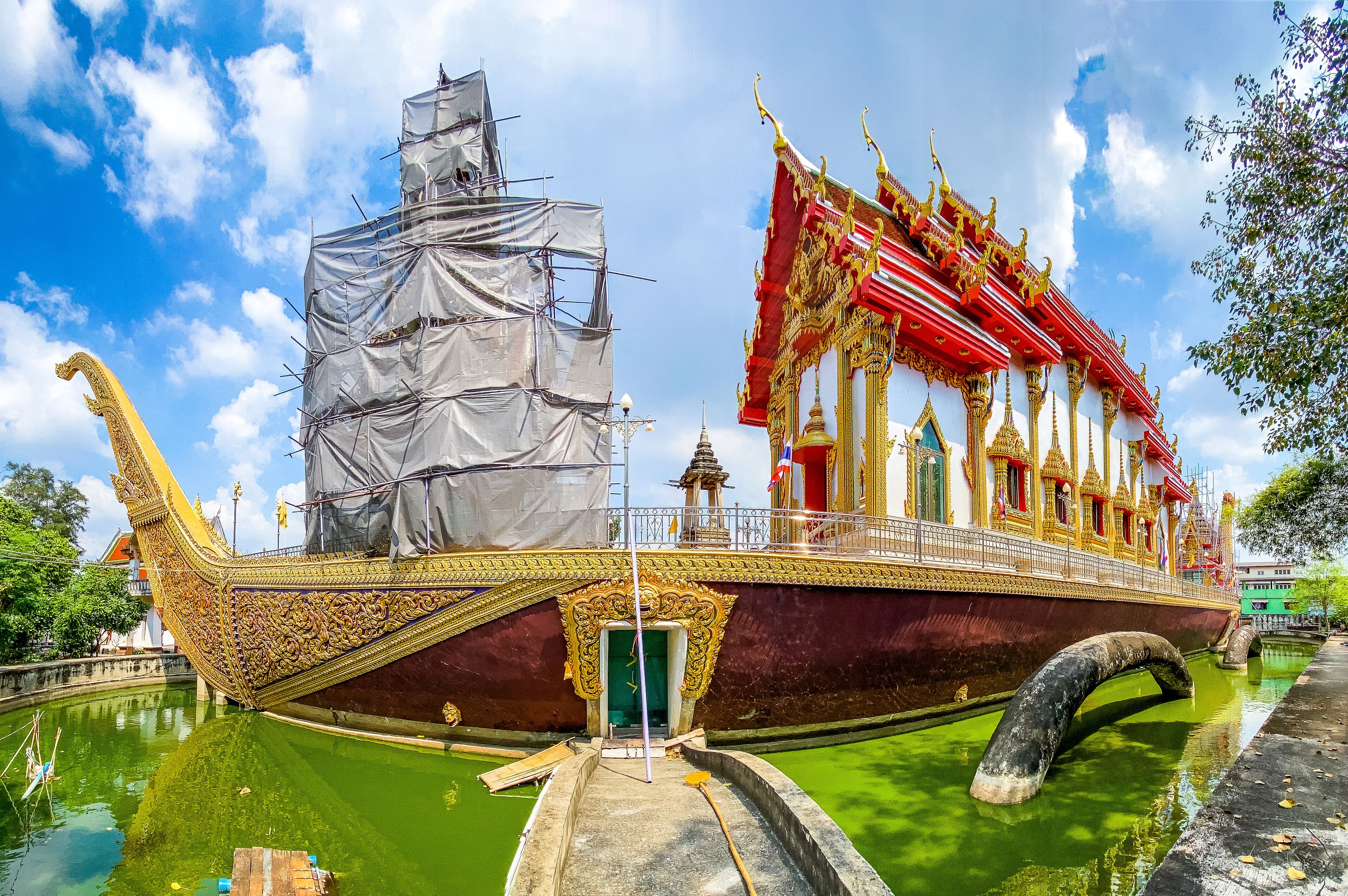 A traditional boat with ornate decorations and a covered structure, partially in the water.