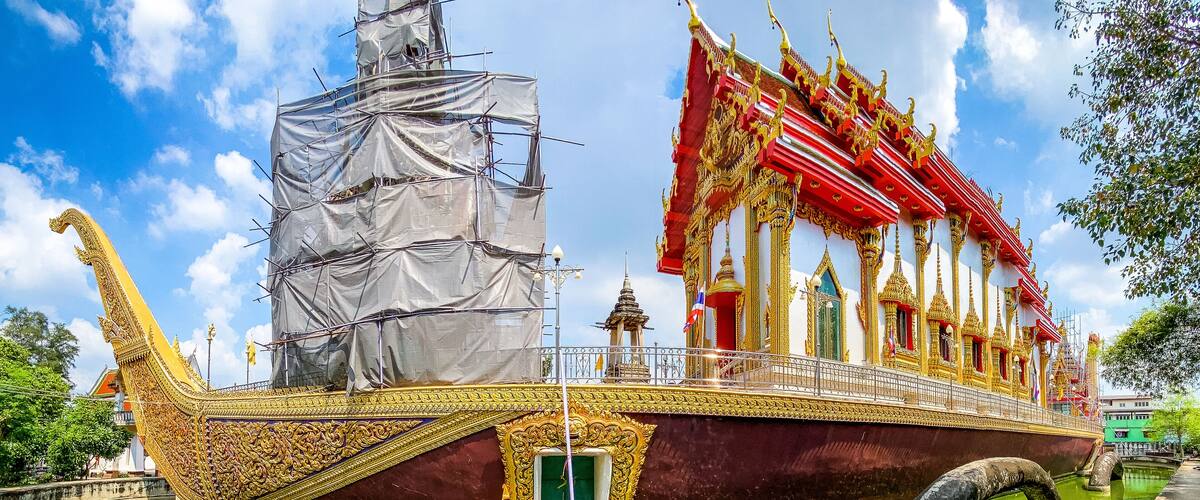 A traditional boat with ornate decorations and a covered structure, partially in the water.