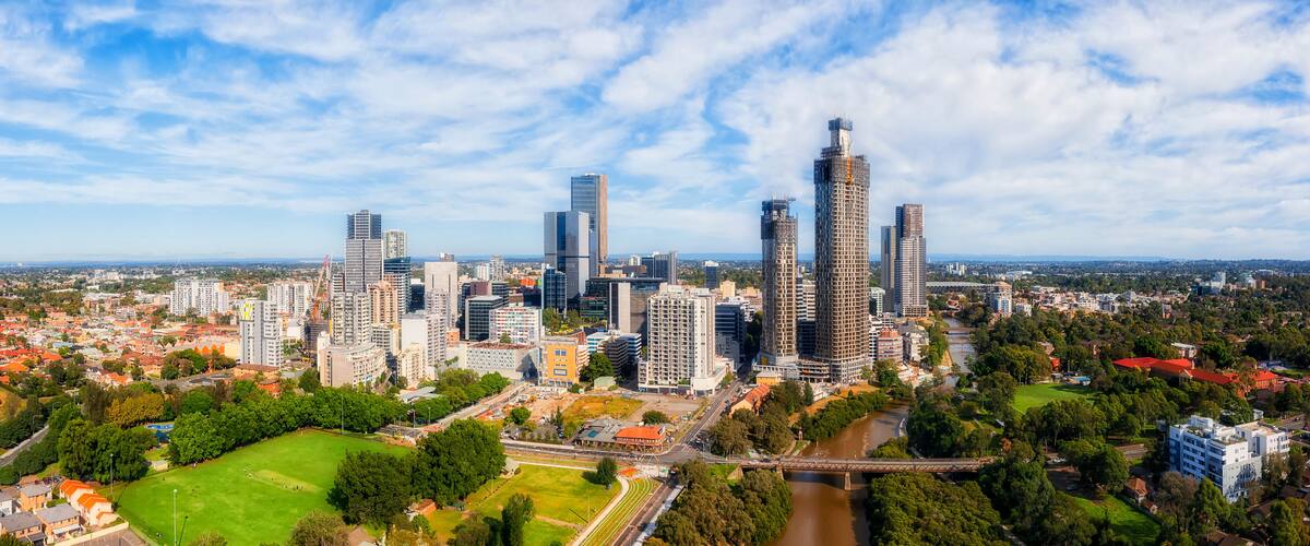 A cityscape with a prominent skyscraper, a river, and surrounding greenery.