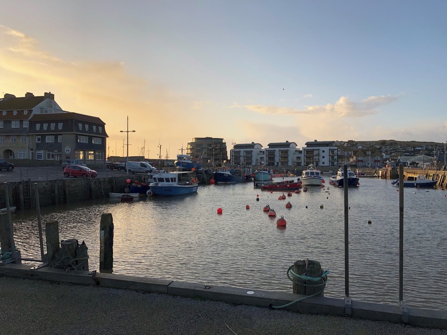 The boats in he harbour and the sun going down makes a colourful photo.