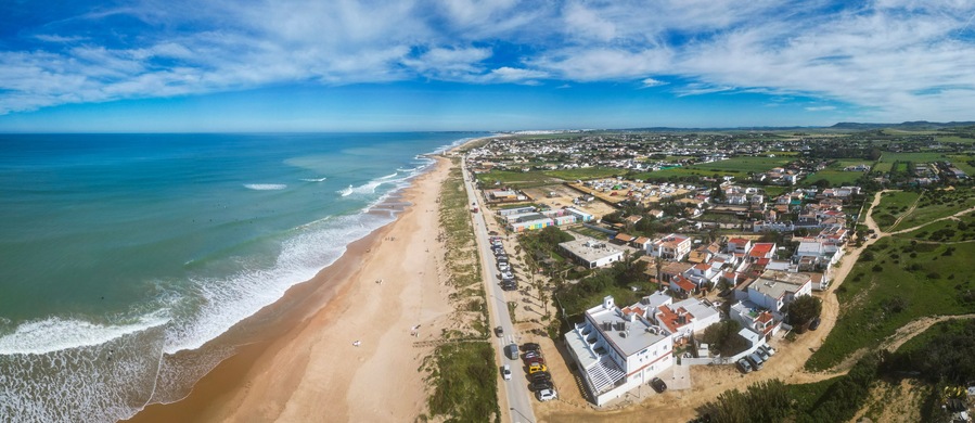 Un pueblo costero con playa, casas y cielo despejado.